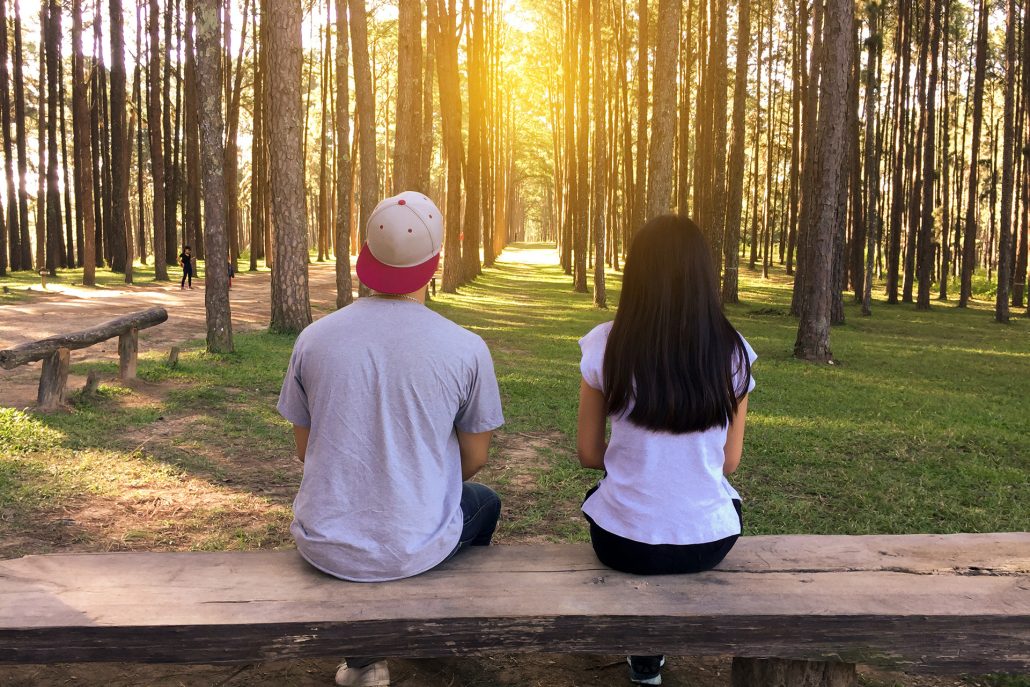 man and woman sitting on bench